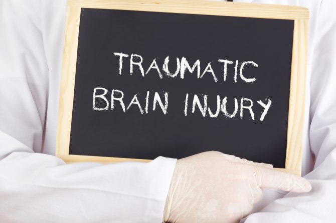 Doctor holding traumatic brain injury sign in Kansas City, MO