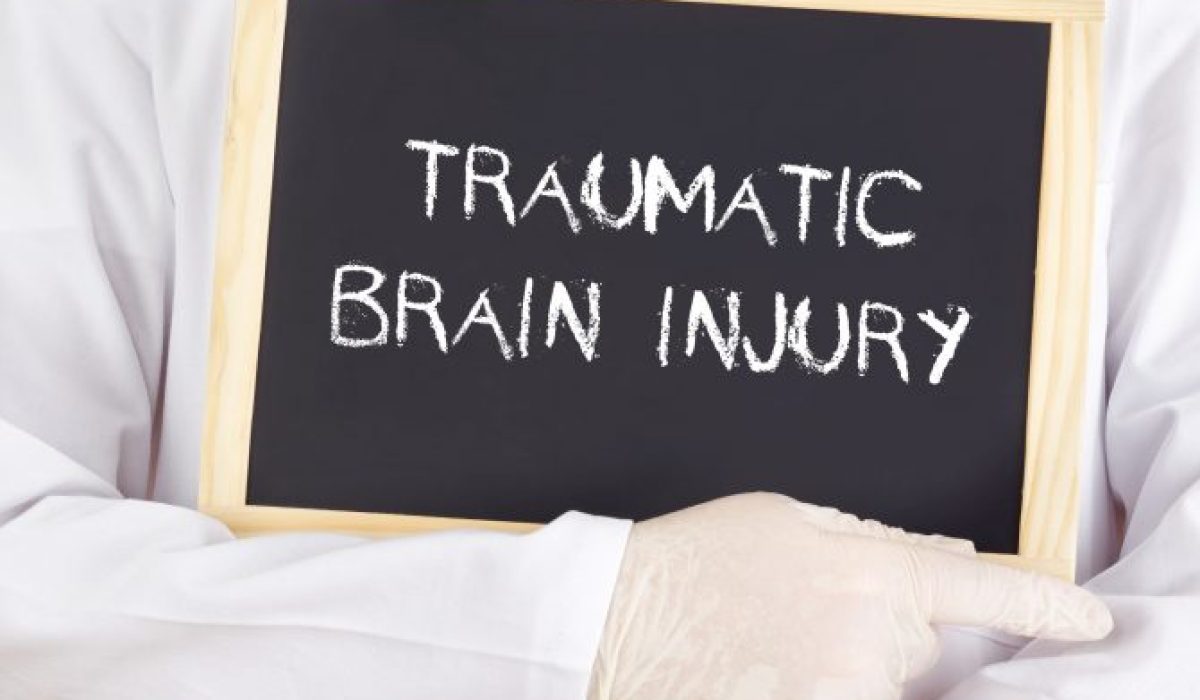 Doctor holding traumatic brain injury sign in Kansas City, MO